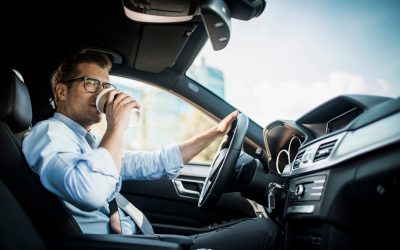 Close up photo of a businessman driving a car while drinking coffee